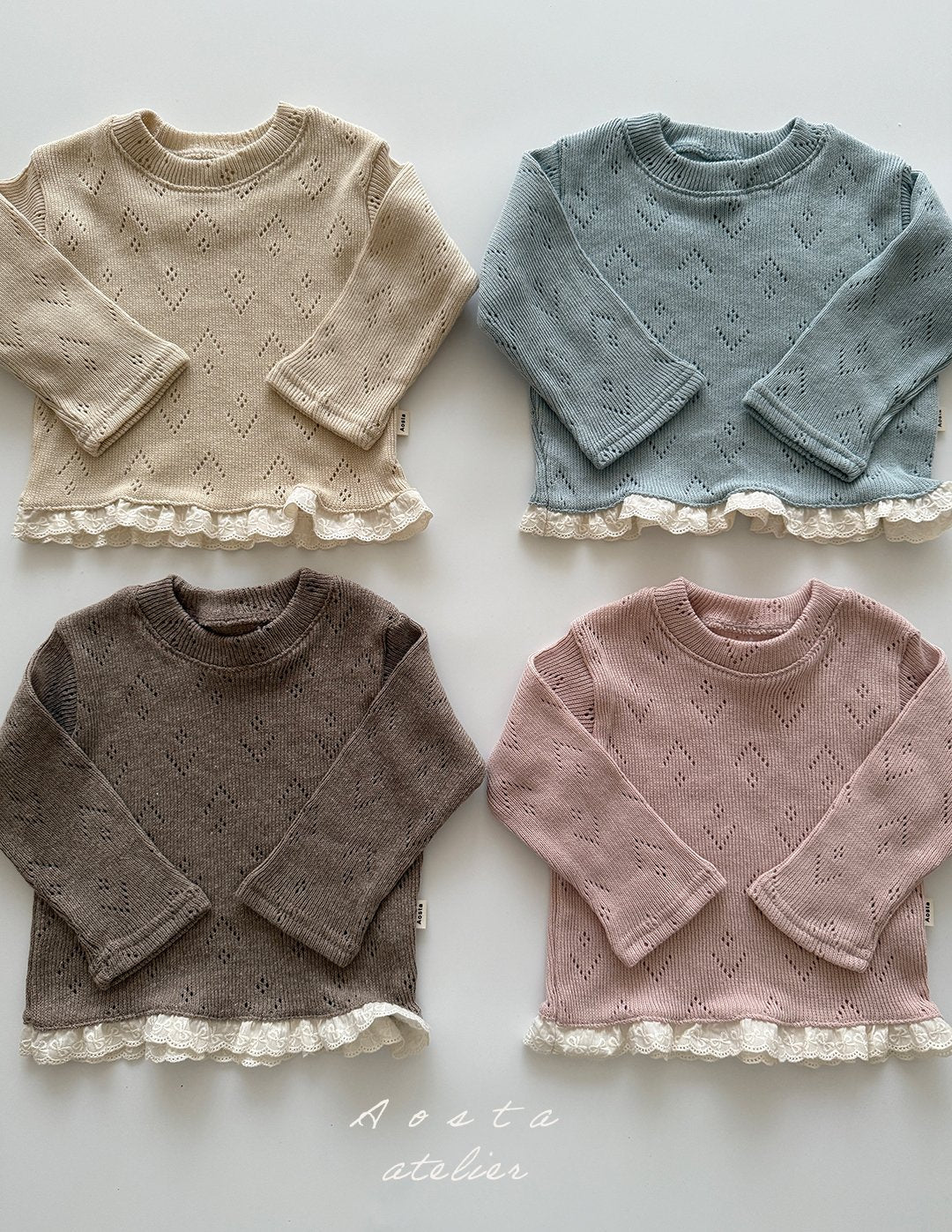 Four knitted sweaters in beige, blue, brown, and pink with lace trim on a white background.
